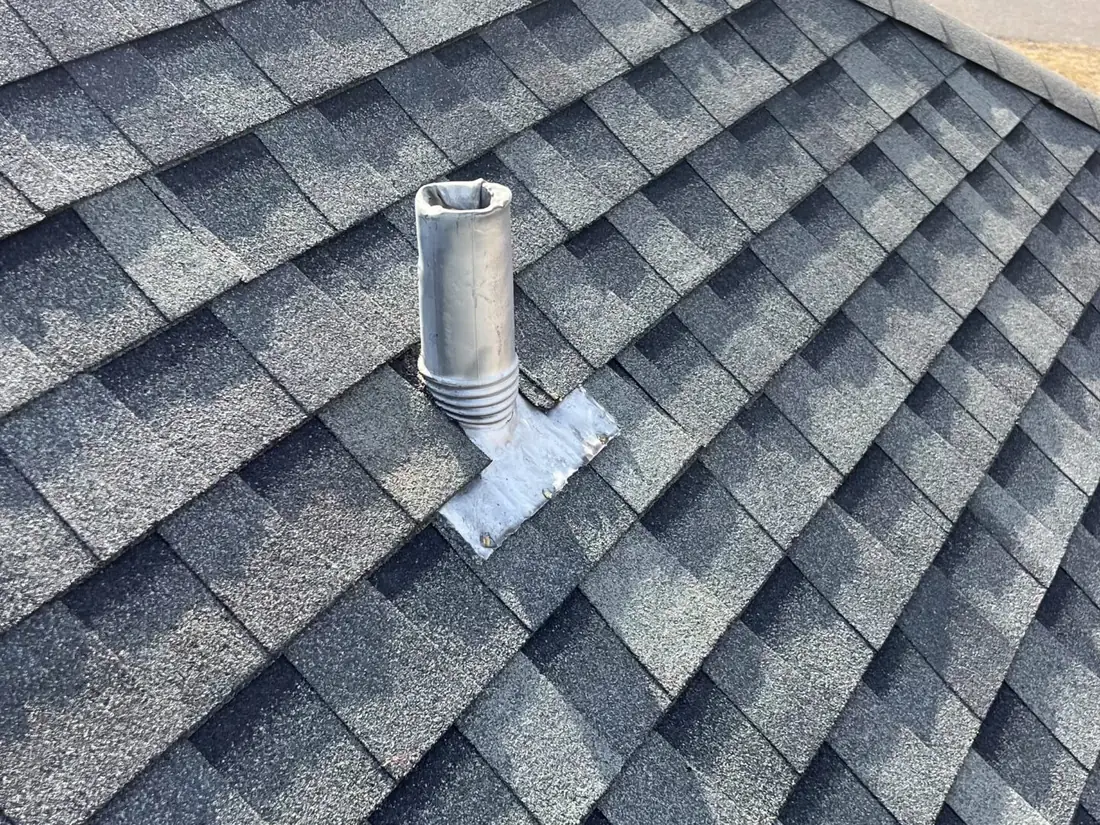 Close-up of new shingles and pipe-boot flashing detail